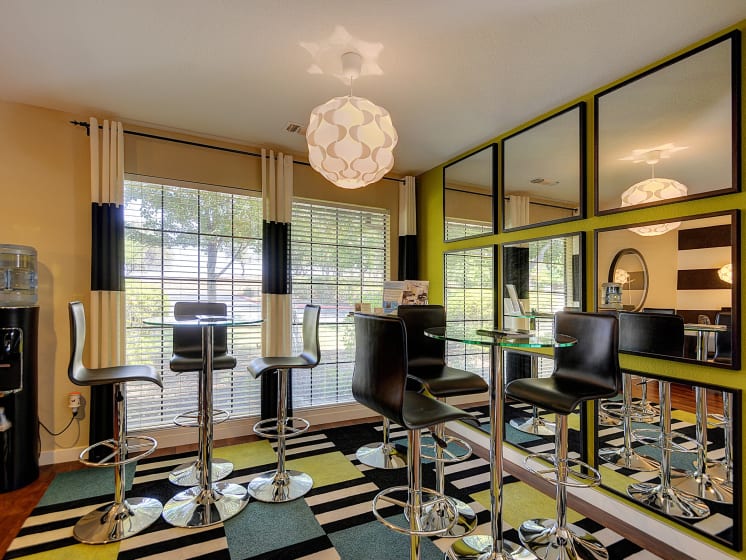 Office Area with Mirrors, Tall Ascending Black Chairs, Round Glass Tables and Colorful Patterned Rug